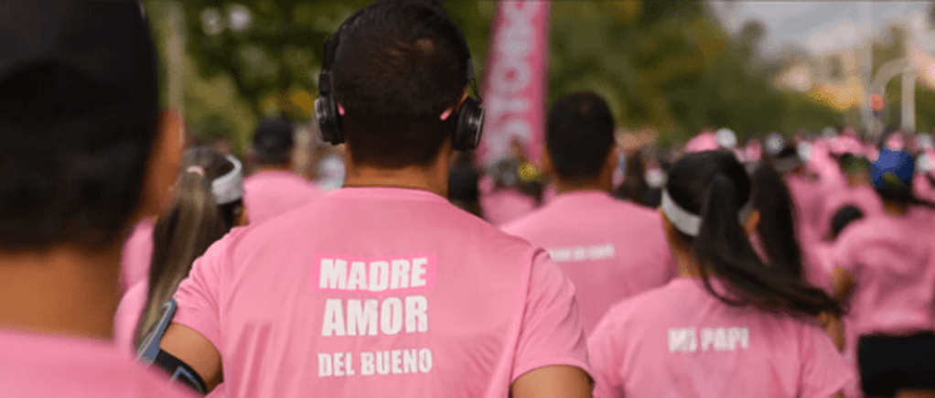 Grupo diverso de corredores participando en una carrera bajo el sol, promoviendo el deporte y la vida saludable en Colombia.