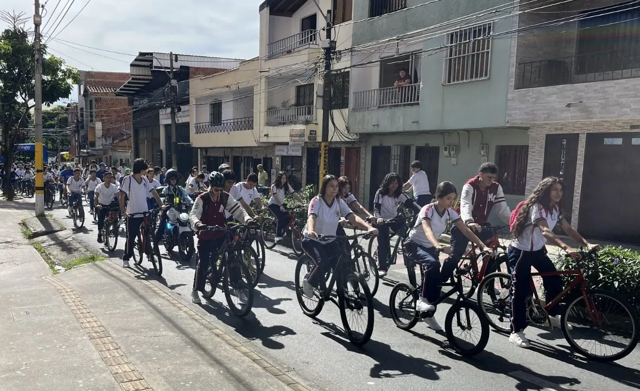 Ciclistas urbanos participando en una rodada de movilidad sostenible por las calles culturales de Bello, Antioquia