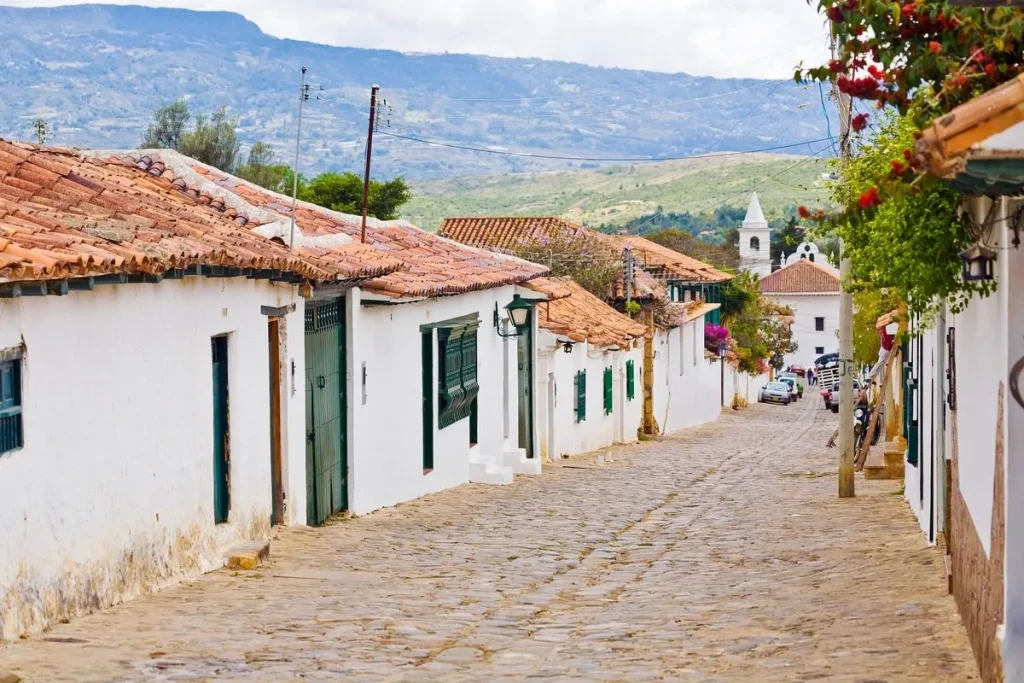 Una hermosa calle empedrada de Barichara con su arquitectura colonial característica y paredes de tapia pisada que invitan a caminar con calma