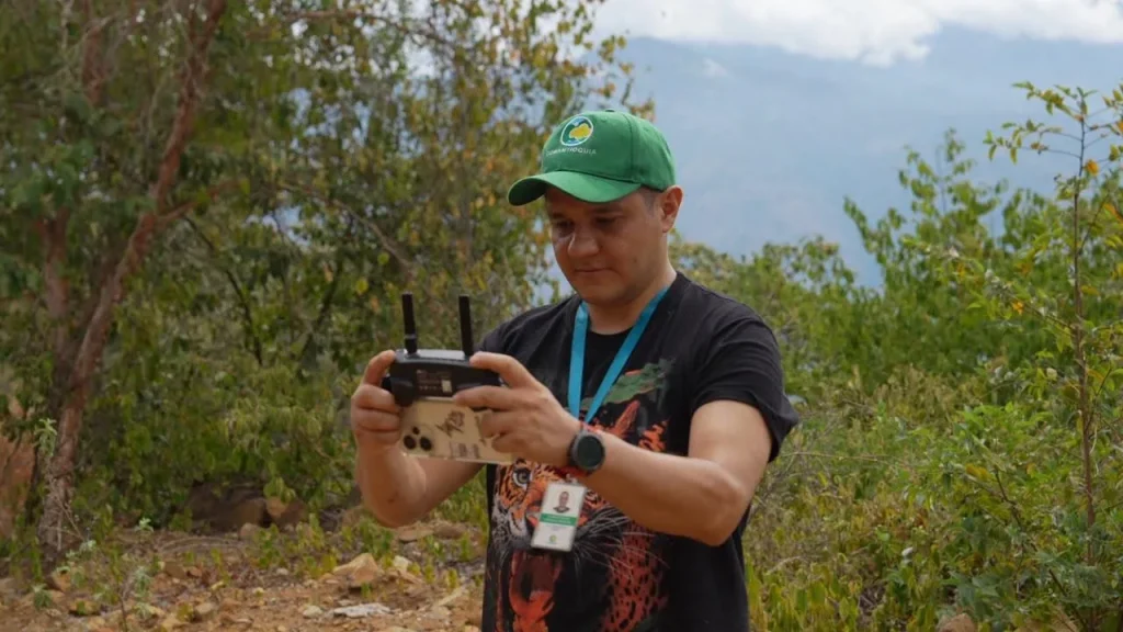 Un sendero ecológico en Antioquia rodeado de vegetación seca donde los viajeros caminan con responsabilidad para prevenir incendios forestales.